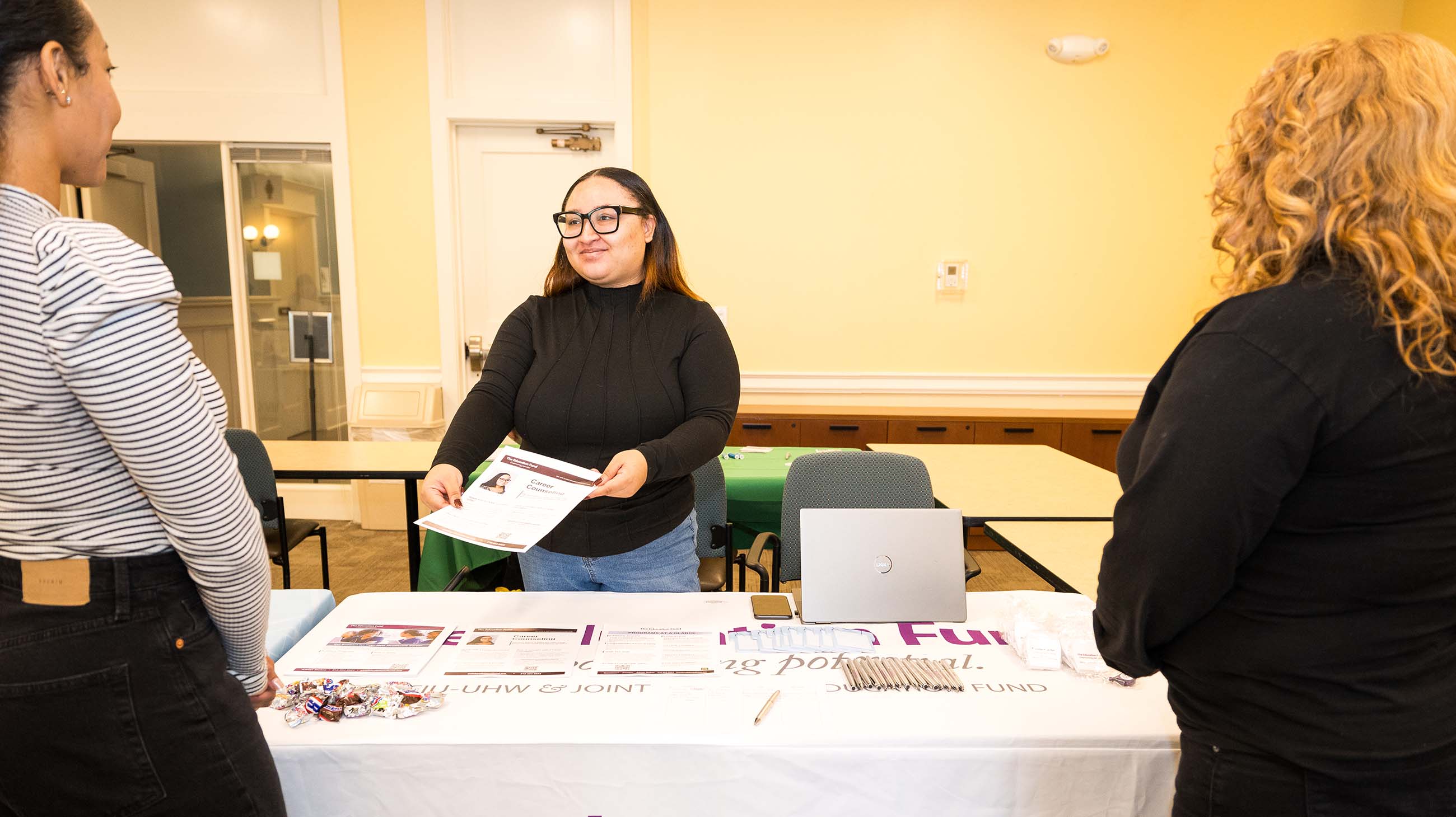 person handing out information at EdFund event