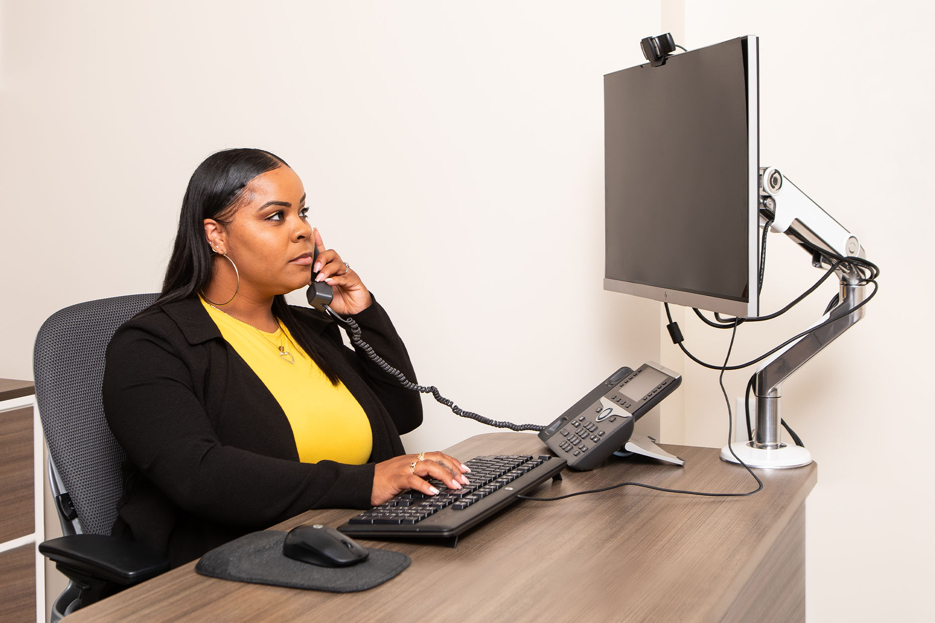 professional woman taking call while in front of computer