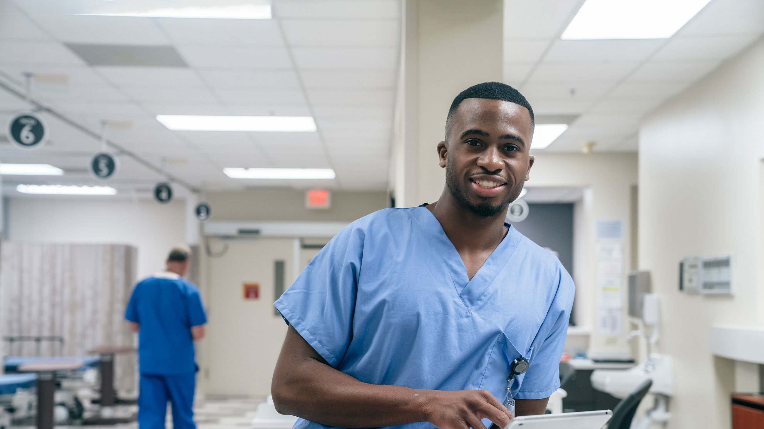 man in scrubs holding a clipboard