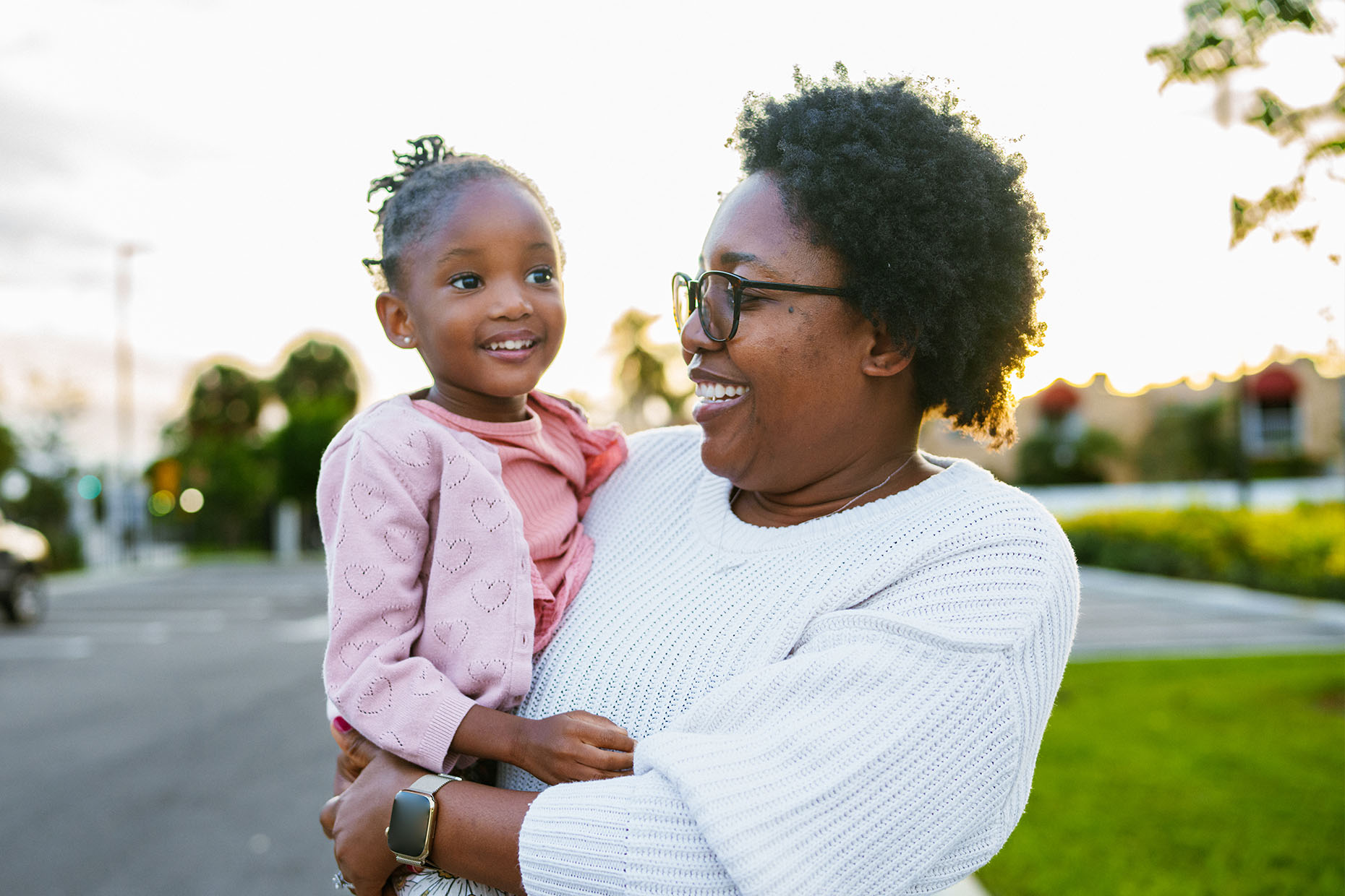 Mother holding toddler daughter and smiling