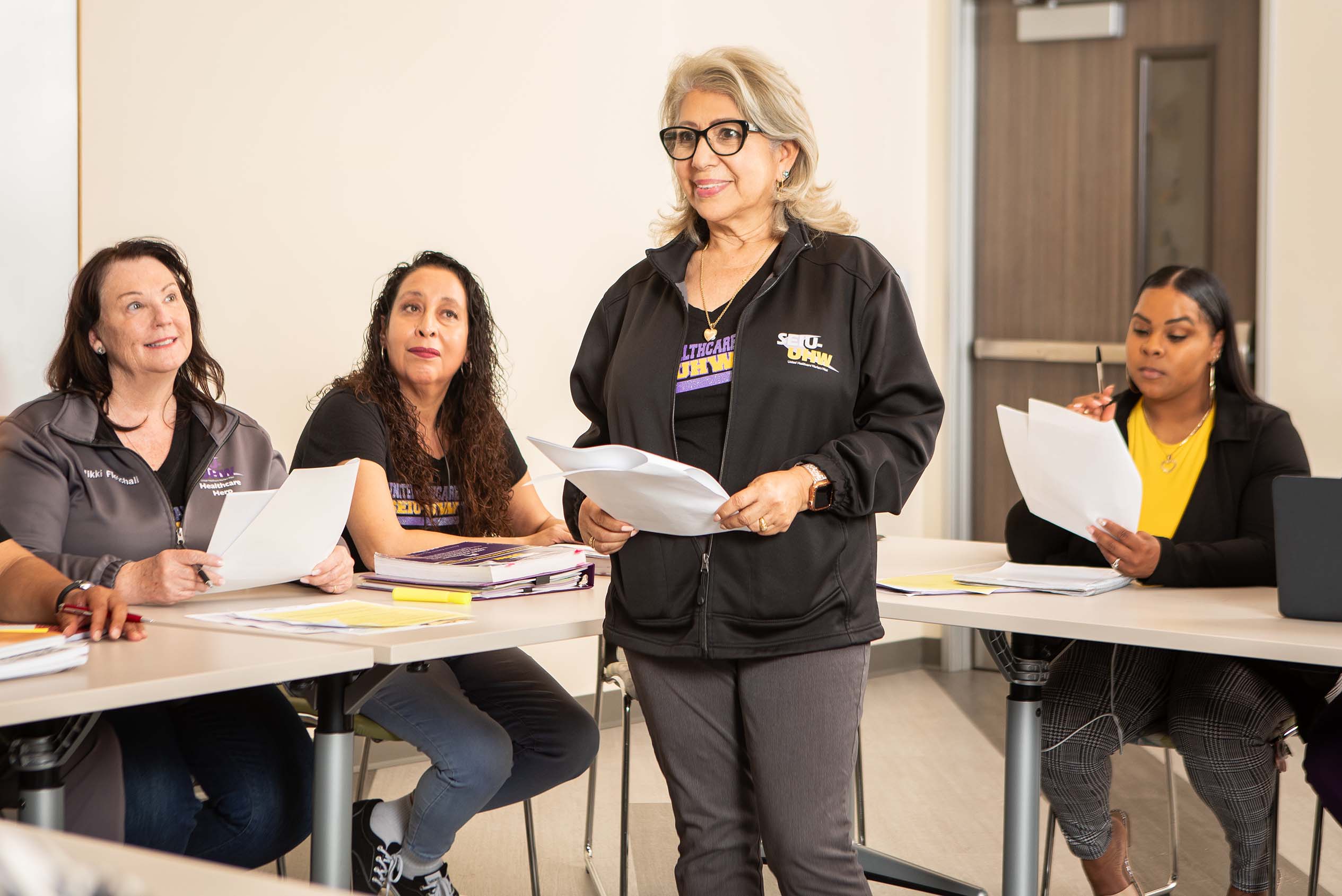 Small classroom group of three adult students listening to instructor