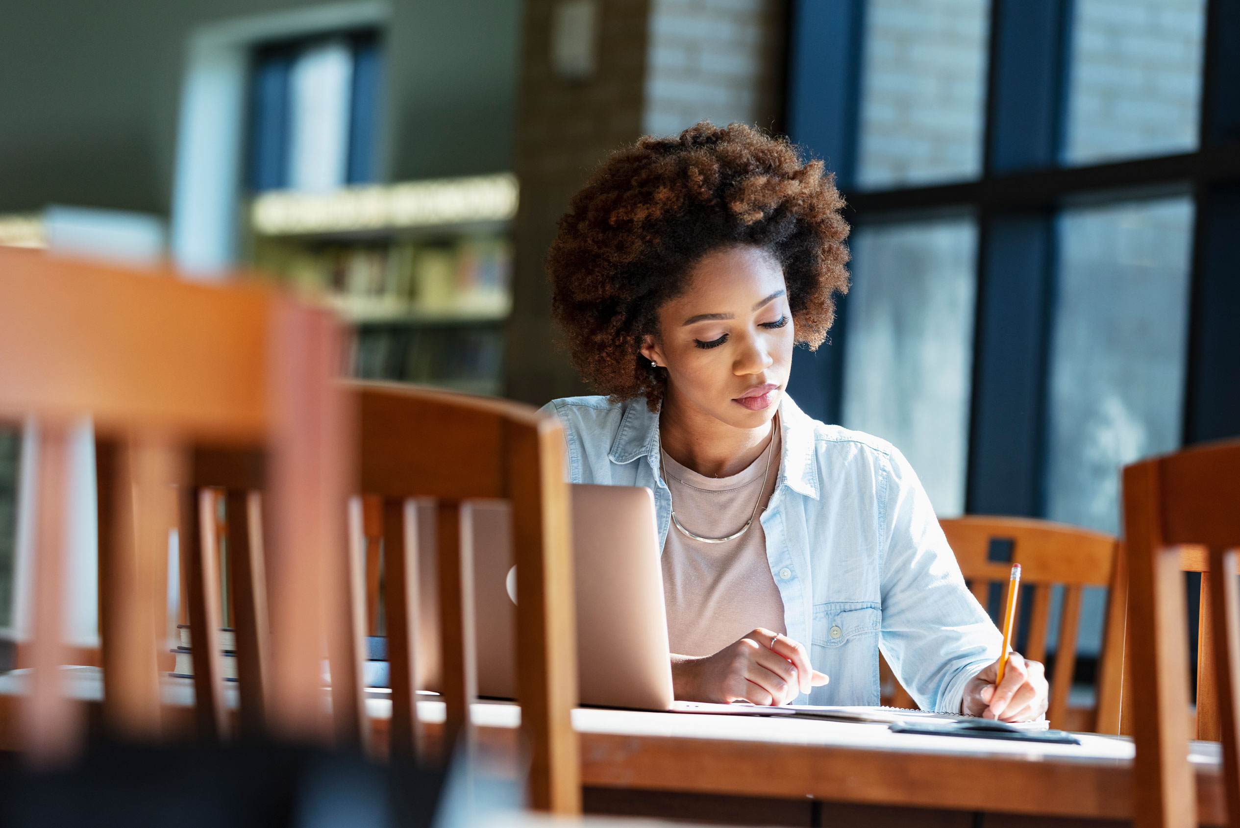Female studying in library with laptop