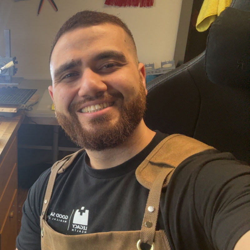 man smiling at camera in overalls