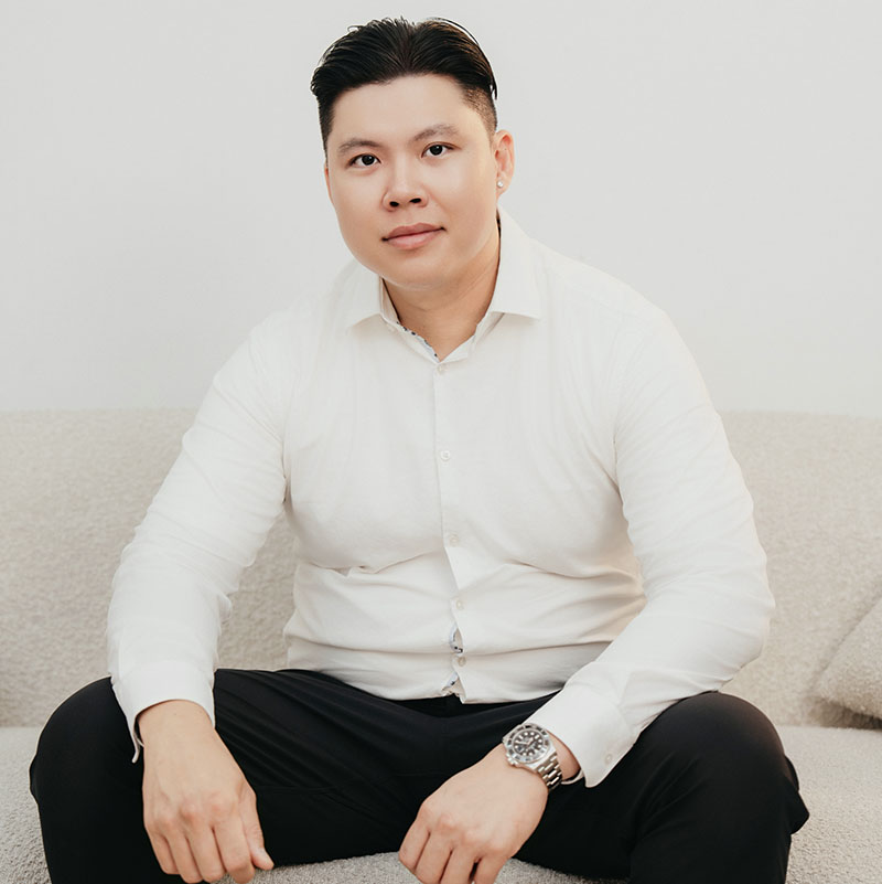 portrait of a young man in white collared shirt sitting on sofa